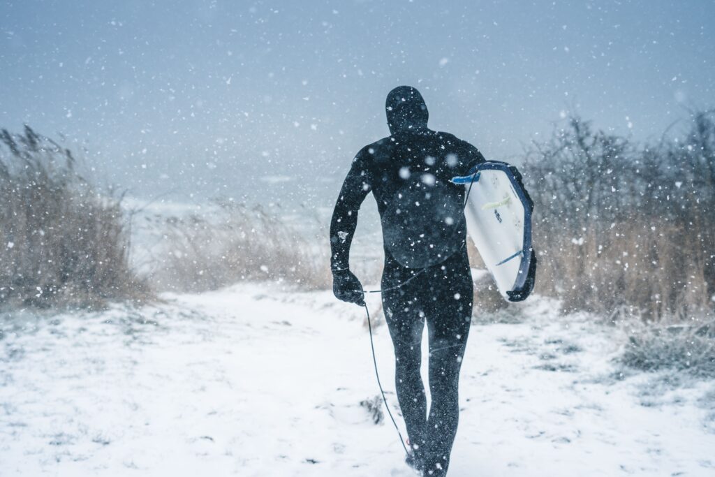 Surfer in snow. Shows all year round discipline.