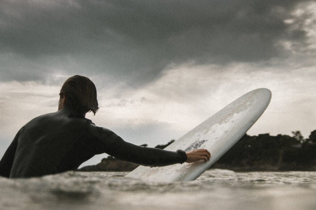 Surfer sitting on a surfboard waiting for a wave.